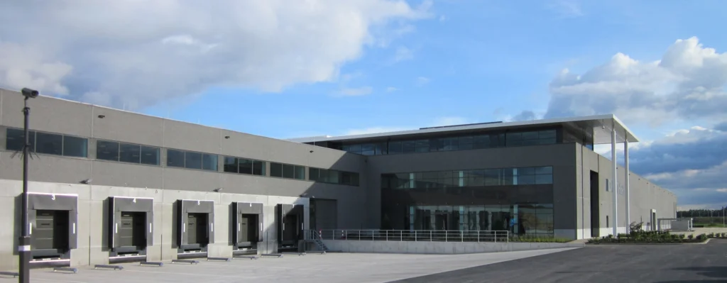 A large industrial building with multiple loading docks under a partly cloudy sky.