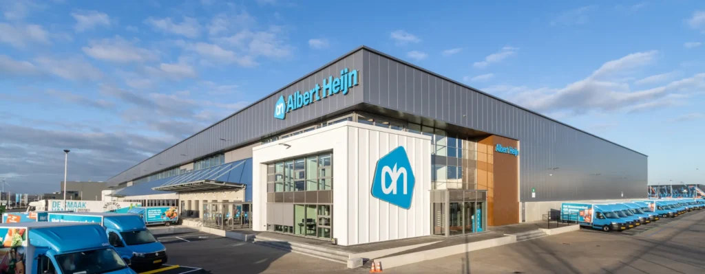 Albert Heijn distribution center with delivery trucks parked in front.