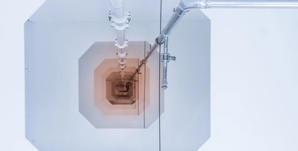 A view into a white shaft containing metal pipes, showing vertical structures in civil engineering.