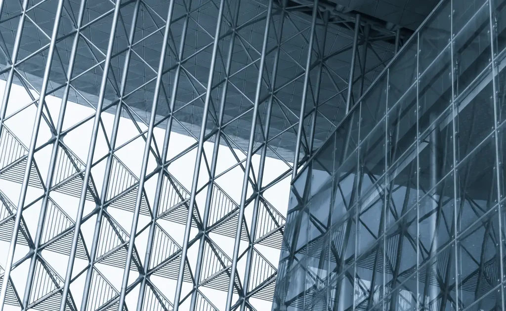 Geometric metal framework and glass facade of a modern architectural structure.