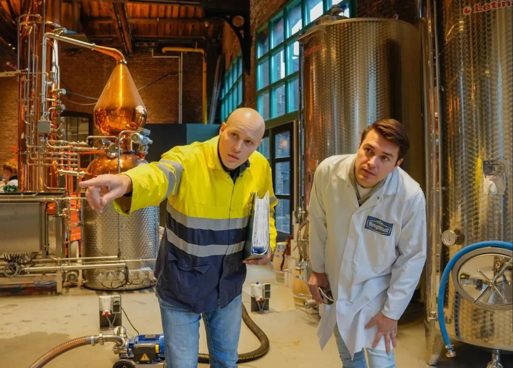 A Vicoma employee is pointing something out to a customer at an industrial site.