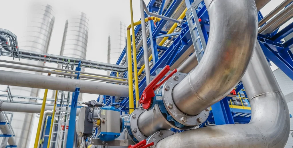 Industrial pipework system with red valves and blue components.