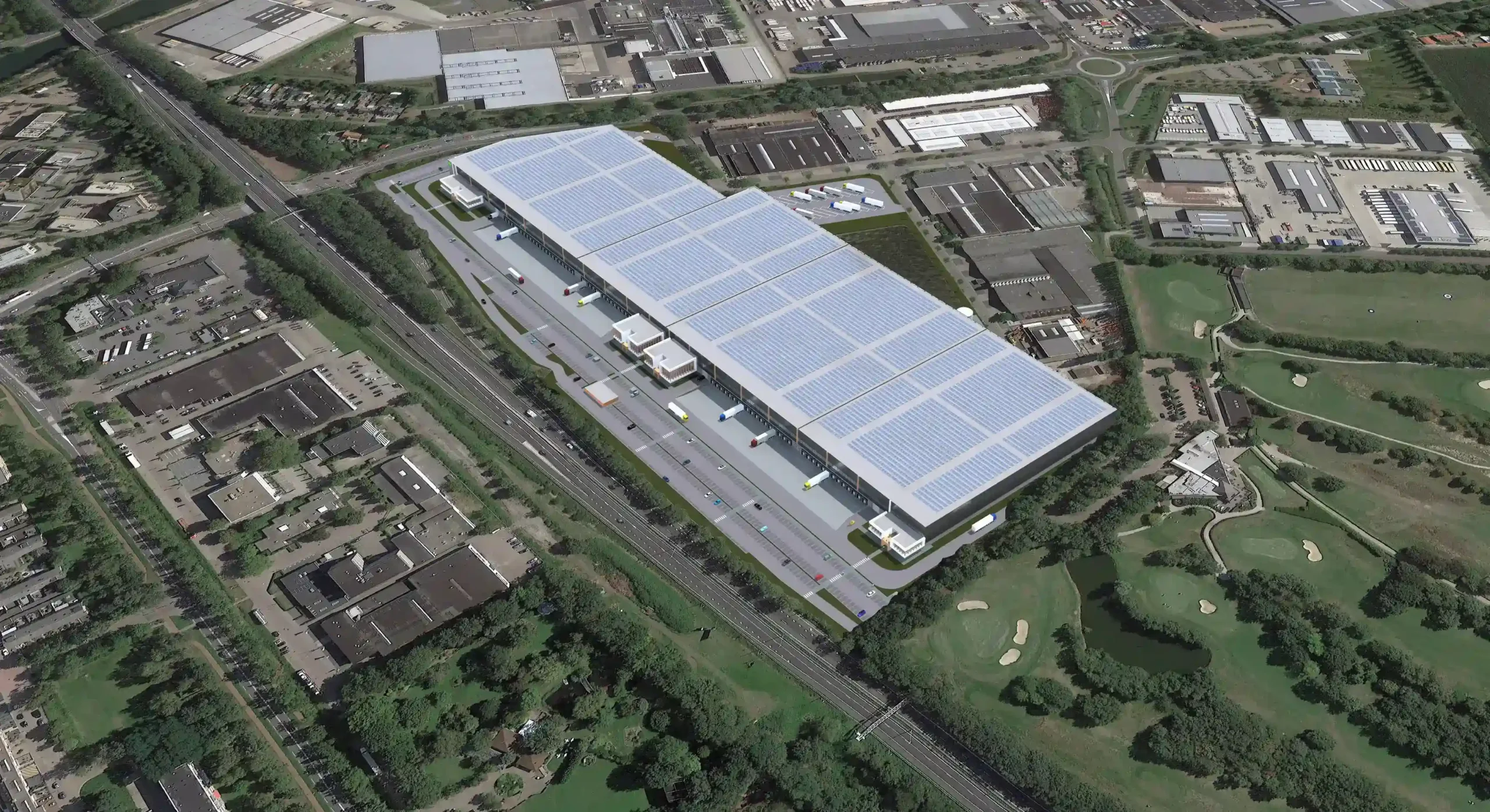 Luchtfoto van een groot distributiecentrum met zonnepanelen op het dak, omgeven door een industriegebied en een golfbaan.